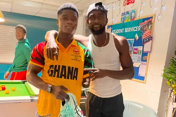 Joseph Paul Amoah presents racing spikes to para athlete Hayford Addae