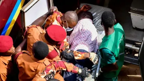 Veteran Ugandan opposition politician collapses in court and in ICU, his wife says